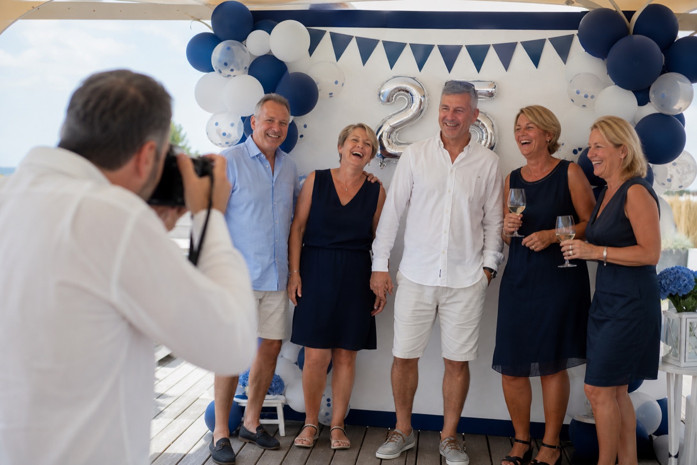 Fotograf dokumentiert das Vereinsjubiläum vor einer Fotowand
